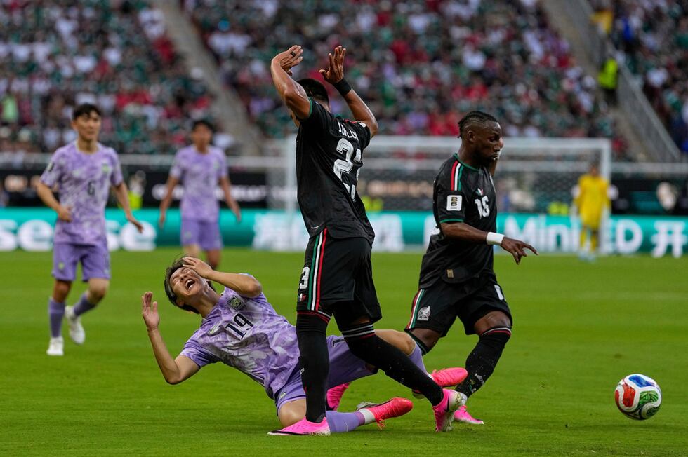 Lee Kang-in, de Corea del Sur, cae al disputar un balón con Jesús Gallardo, de México, en el...