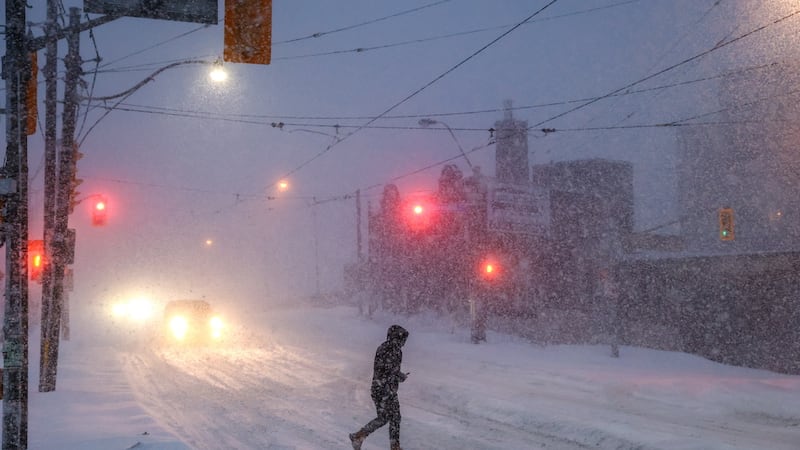 Gente camina por el centro de Toronto mientras una tormenta invernal pasa por la región, el...