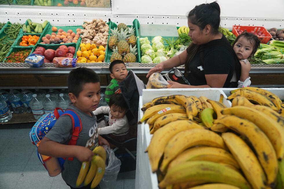 Una madre inmigrante originaria de Guatemala compra frutas para sus hijos con el saldo...