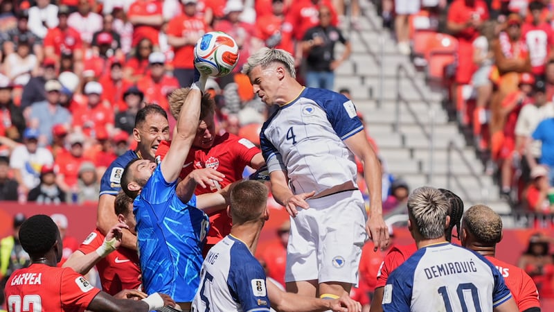 Canada goalkeeper Maxime Crepeau punches the ball clear as Bosnia's Tarik Muharemovic attempts...
