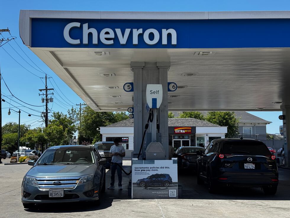 Un letrero en el que se culpa a las políticas del estado por el elevado costo de la gasolina,...