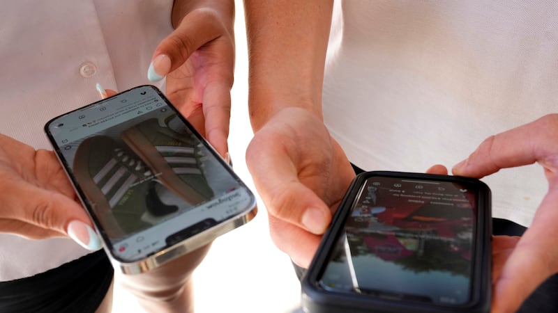 ARCHIVO – Varios jóvenes usan sus teléfonos celulares para mirar redes sociales en Sydney, el...